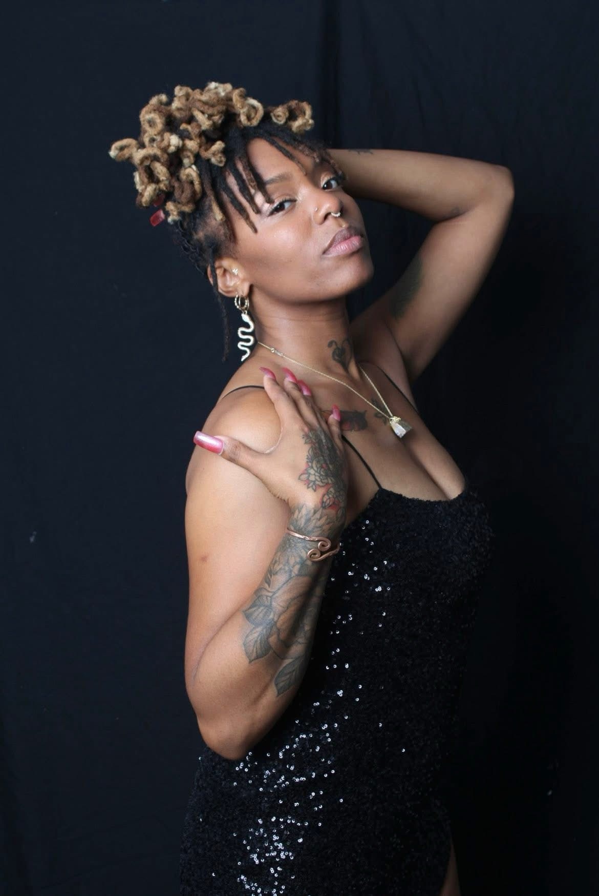 Love Lei performing live — black sequin dress, over-shoulder pose